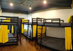 a group of bunk beds in a room with yellow curtains at Best Bed Suvarnabhumi Hostel in Lat Krabang