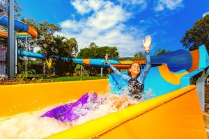 a woman riding a water slide at a water park at Solitary Islands Resort in Wooli