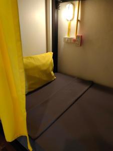 a room with a yellow couch and a light at Best Bed Suvarnabhumi Hostel in Lat Krabang