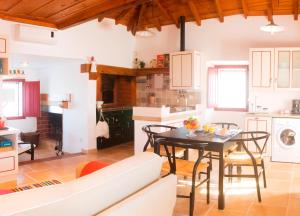 a kitchen and dining room with a table and chairs at Casas da Tia Alice in Mafra