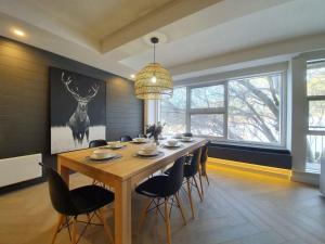 a dining room with a wooden table and chairs at Mt Buller Chalet Hotel & Suites in Mount Buller