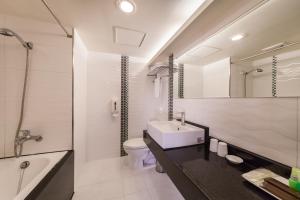 台北的住宿－華麗大飯店Ferrary Hotel，浴室配有盥洗盆、卫生间和浴缸。