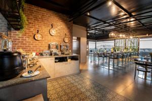 班加罗尔Hotel Avora Tree By Rivido Kempegowda Airport Road的一间带柜台的厨房和一间带桌子的酒吧