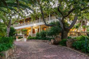 een huis met een boom en een stenen oprit bij Ibis House in Kaapstad