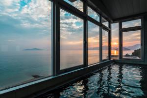 una piscina en una casa con vistas al océano en Uminos Spa & Resort, en Etajima