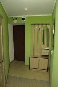 baño con paredes verdes, lavabo y espejo en Apartment on Khreshchatyk 200 center en Cherkasy