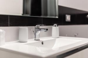 a bathroom sink with a faucet and a mirror at Nùe Rooms in Cagliari