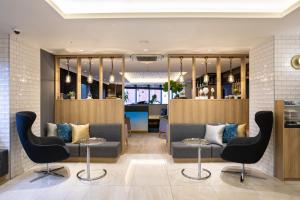 a waiting room with couches and chairs and a table at Hotel Prefort Nishiakashi in Akashi