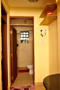 a bathroom with a toilet and a sink at Sherry Homes - Raha in Nairobi