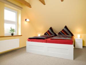 a bedroom with a bed with red sheets and a window at Haus Gestrandet in Kaltenhof