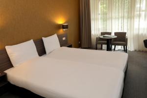 Postel nebo postele na pokoji v ubytování Golden Tulip Ampt van Nijkerk