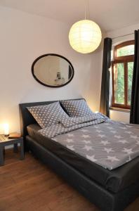 a bedroom with a large bed with a mirror on the wall at Alter Bahnhof Otersen in Kirchlinteln