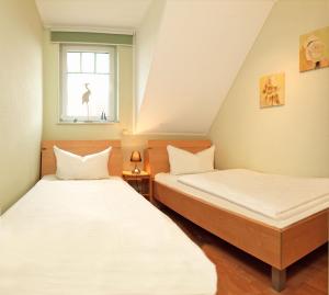dwa łóżka w pokoju z oknem w obiekcie Reihenhäuser Timmendorf Strand Haus Sonnenaufgang w mieście Wyspa Poel