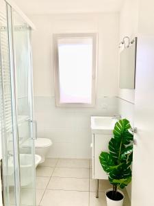 een badkamer met een wastafel, een toilet en een raam bij Nuovissimo piano terra a due passi dal mare in Cervia