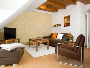 - un salon avec un canapé et une télévision dans l'établissement Appartements Am Reiterhof Seepferdchen, à Timmendorfer Strand