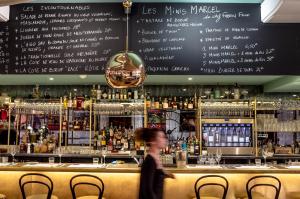 a person walks past a bar with a menu at Suites The Marcel in Sète
