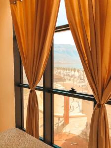 ein Fenster mit orangefarbenen Vorhängen und Stadtblick in der Unterkunft MiMi's Beach Apartment in Vlorë