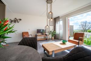 ein Wohnzimmer mit Esstisch und Stühlen in der Unterkunft Grasse 140 - Kustpark Village Scaldia in Hoofdplaat + 37 Fotos