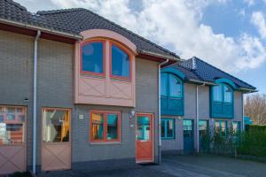 ein Haus mit roten Türen und blauen Fenstern in der Unterkunft Grasse 140 - Kustpark Village Scaldia in Hoofdplaat