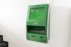 uma máquina de multibanco verde sentada numa parede em Hostel Messe Laatzen em Hanôver