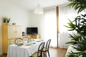 een eetkamer met een witte tafel en stoelen bij Grazioso appartamento a due passi dal mare in Cervia