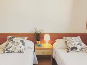 - une chambre avec deux lits et une table avec une lampe dans l'établissement Grazioso appartamento a due passi dal mare, à Cervia