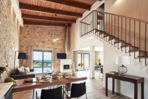 a dining room and living room with a stone wall at Anar Villas Rhodes in Koskinou