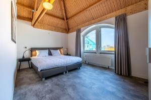 ein Schlafzimmer mit einem Bett und einem großen Fenster in der Unterkunft Grasse 140 - Kustpark Village Scaldia in Hoofdplaat