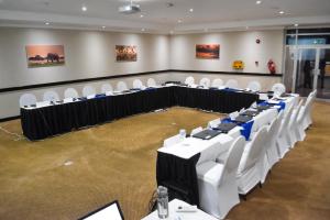 a conference room with white chairs and tables in it at Cresta Bosele Hotel in Selebi-Pikwe +22 photos