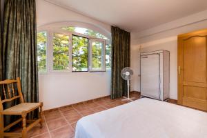 a bedroom with a bed and a window and a chair at Venta del alamo in Dúrcal +22 photos