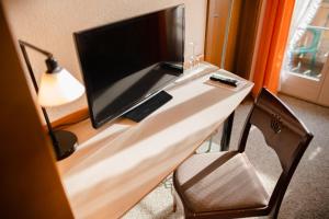 einen Schreibtisch mit einem Monitor und einem Computer darauf in der Unterkunft Hotel Restaurant Bad Gutenburg in Lotzwil