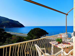 einen Balkon mit einem Tisch, Stühlen und Meerblick in der Unterkunft Spazioso appartamento Vista Mare in Levanto