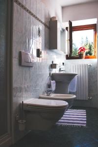 een badkamer met een toilet en een wastafel bij Hotel Gembro in Chiesa in Valmalenco
