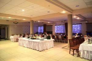 a banquet hall with tables and chairs with white tablecloths at Zajazd Ostęp in Gorzyń