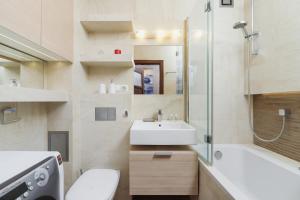 uma casa de banho com um lavatório, um WC e uma banheira em Apartments Obopólna Cracow by Renters em Cracóvia
