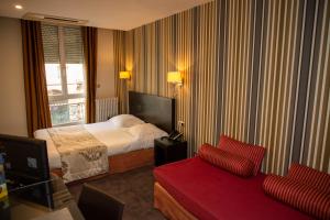 um quarto de hotel com uma cama e um sofá em Grand Hôtel d'Orléans em Toulouse