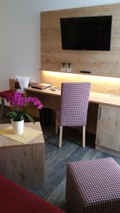 a room with a desk with a tv and a chair at Landhotel Böld Oberammergau in Oberammergau