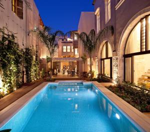 uma piscina no meio de um edifício em Rimondi Boutique Hotel - Small Luxury Hotels of the World em Rethymno Town