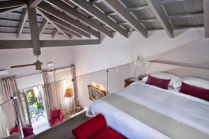 a bedroom with a large white bed and red chairs at Rimondi Boutique Hotel - Small Luxury Hotels of the World in Rethymno Town