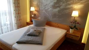 a bed with two pillows sitting on top of it at Landhotel Böld Oberammergau in Oberammergau