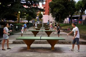 a group of people playing ping pong in a park at Hotel Zorna Plava Laguna in Poreč