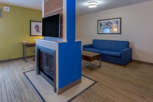 a living room with a fireplace and a blue couch at Holiday Inn Express - Indianapolis - Southeast by IHG in Indianapolis