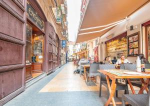 una calle con mesas y gente sentada en un restaurante en Estudios Muñoz, en Alicante