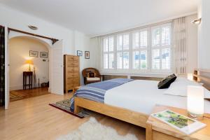 una camera con un grande letto e un tavolo di Veeve - South Kensington Garden Apartment a Londra