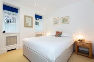 En eller flere senge i et værelse på Veeve - South Kensington Garden Apartment
