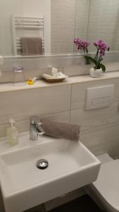 a bathroom with a sink with a vase of flowers at Landhotel Böld Oberammergau in Oberammergau
