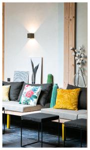 a living room with a black couch and yellow pillows at URBAN LOFT & SPA Marseille in Marseille