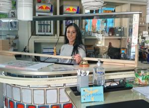 a woman behind the counter of a restaurant at Hotel Aleo in Bochum