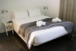 een slaapkamer met een groot bed met handdoeken erop bij Happy People Maragall in Barcelona +30 foto's