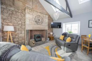 sala de estar con chimenea de piedra y sofás en Host & Stay - Lavender Cottage, en Bamburgh